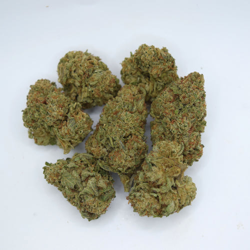 Several dried cannabis buds clustered together on a plain white background.