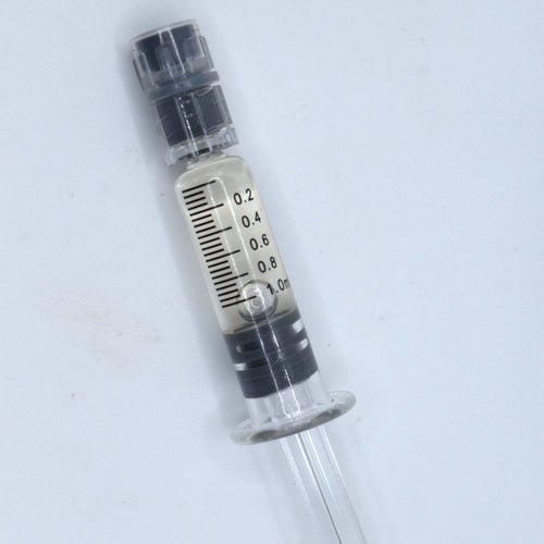 A small CBC filled clear plastic syringe-style tube with black measurement markings and a black cap, shown on a plain light background.