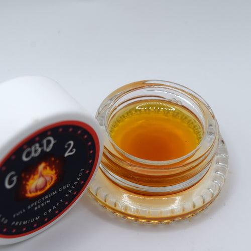 G2 CBD Full Spectrum Extract with golden resinous texture and a deep garlic, sweet kush, earthy resin, herbal spice, and heavy gas profile.