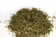 Bag of mixed THCa flower shake in 28g format with trichome-coated flakes and small popcorn nugs.