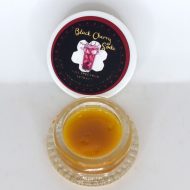 Black Cherry Soda THCa full spectrum sugar showing golden crystals with terpene-rich sauce in glass container.