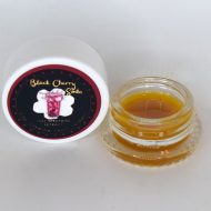 Black Cherry Soda THCa full spectrum sugar showing golden crystals with terpene-rich sauce in glass container.