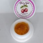 Cherry Dose THCa full spectrum sugar showing golden crystals with terpene-rich sauce and cherry fruit aroma profile.
