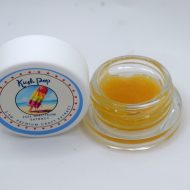 Kush Pop THCa wet sugar showing golden crystalline extract with glossy terpene sauce and citrus kush aroma profile.