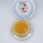 Kush Pop THCa wet sugar showing golden crystalline extract with glossy terpene sauce and citrus kush aroma profile.